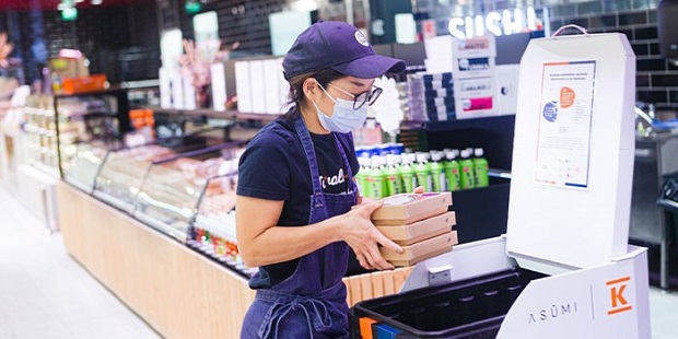 Supermarket staff loaded ordered items into the robot for delivery to the relevant address